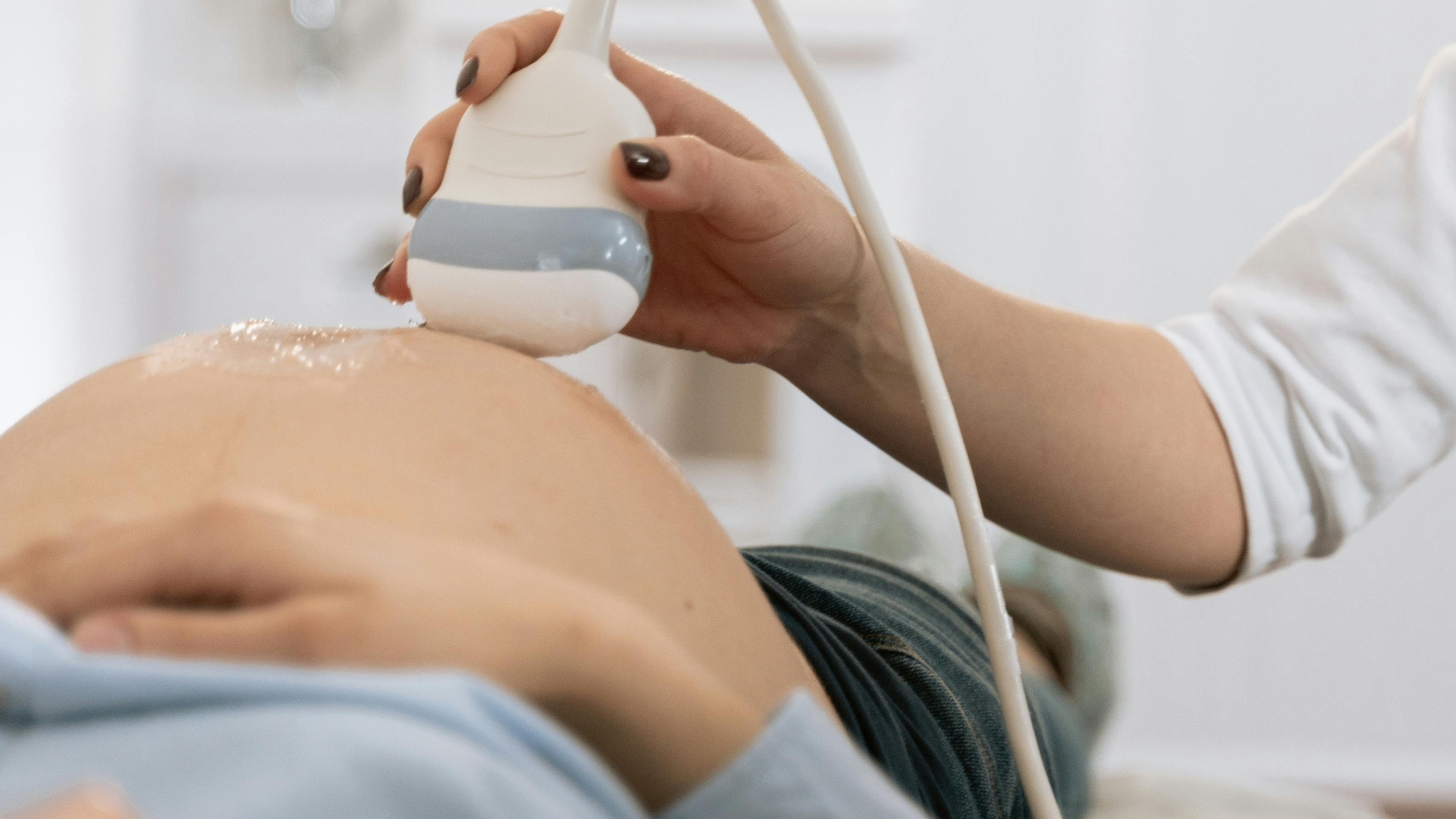 ultrasound tech scanning a pregnant belly