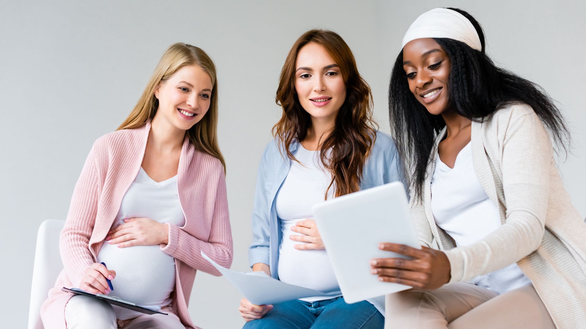 Three pregnant women comparing notes