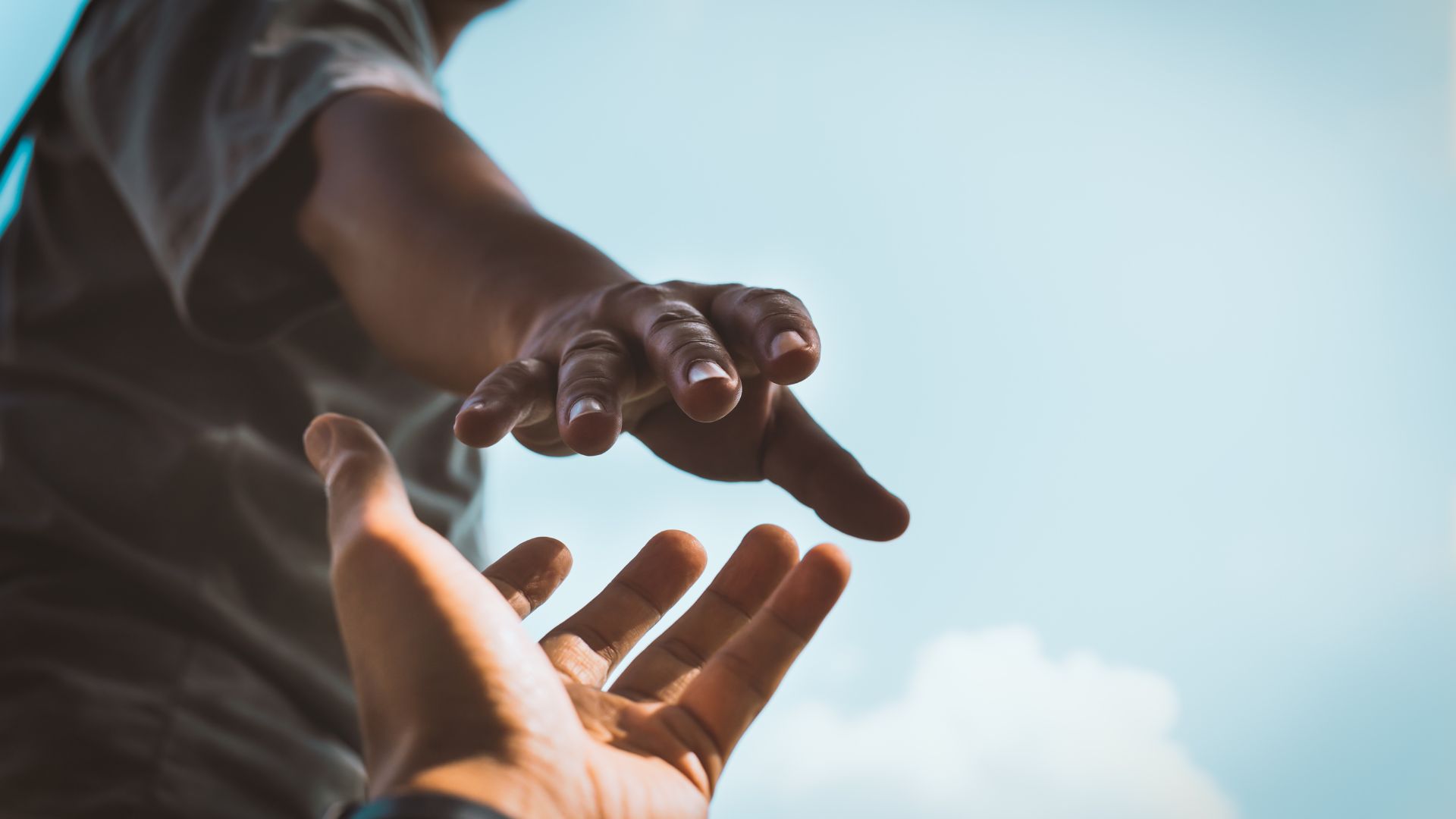 Hand reaching out to grab another hand in aid
