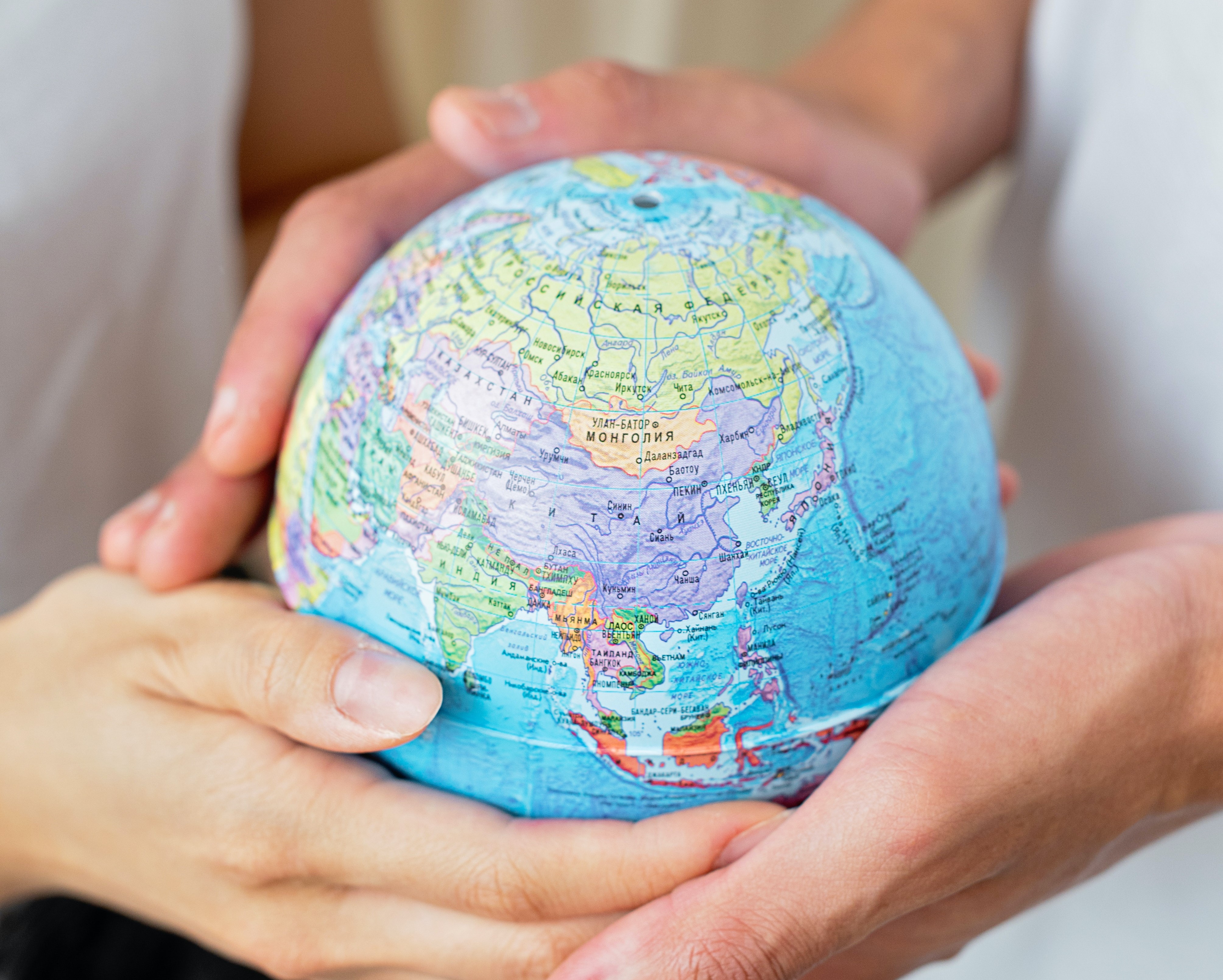 Hands holding small globe