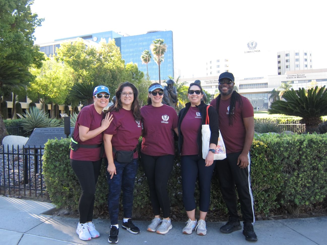 Five participants in the SBH Alumni Walk for Student Food Security pose smilingly on campus in the sunshine
