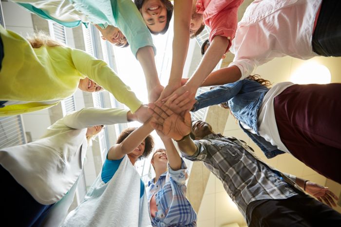 Program members put hands together in a circle 