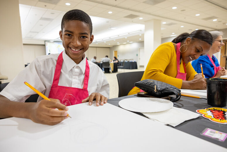 Boy drawing on paper at table