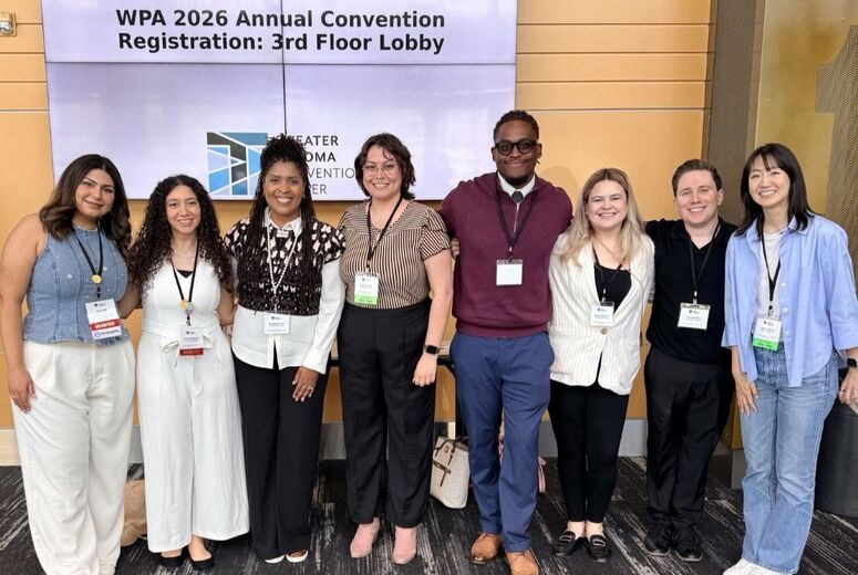 Eight people stand together smiling in front of a welcome banner reading "WPA 2026 Annual Convention" at the Greater Tacoma Convention Center for the 2026 Western Psychological Association Convention in Tacoma, Washington. Several attendees wear conference lanyards and name badges. The third person from left is Dr. Bridgette Peteet, Professor of Psychology at Loma Linda University, and the rest are graduate students from the Department of Psychology.