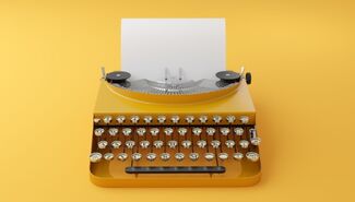 Old-fashioned yellow typewriter against a yellow background. A white sheet of paper is loaded into it.