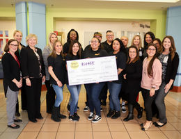 Group of employees stands with check from Spirit of Children
