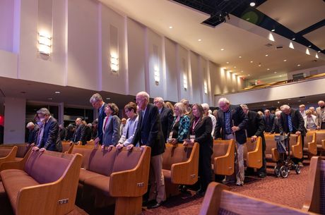 individuals standing in prayer in a chapel