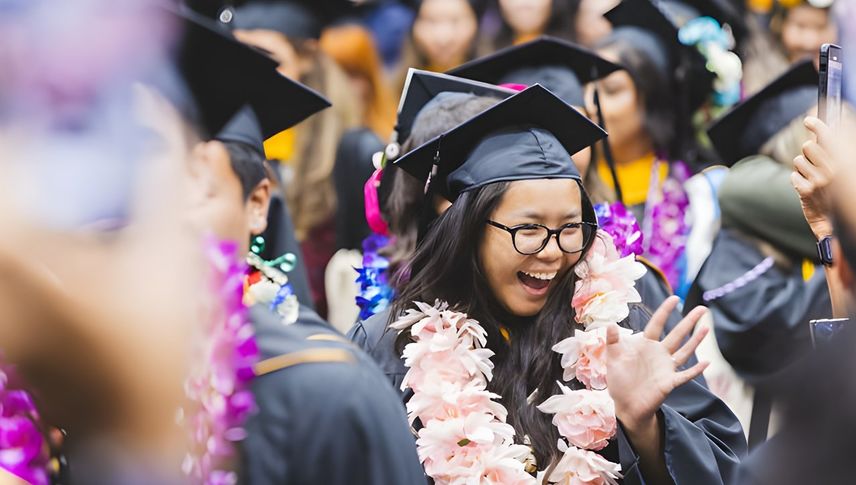 smiling graduate amidst crowd