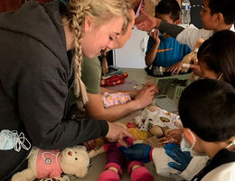 A Child Life Specialist graduate student helps run a teddy bear clinic.