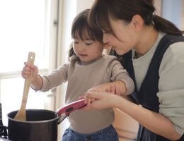 Happy mother and child cooking together on a stovetop