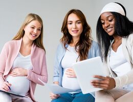 Three pregnant women comparing notes