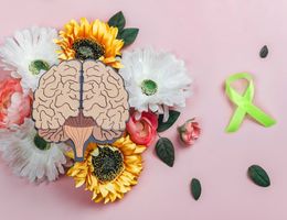 an image of a brain with flowers and a green ribbon