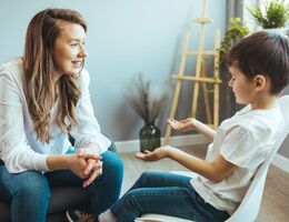 A woman speaks with a young boy in a serene setting