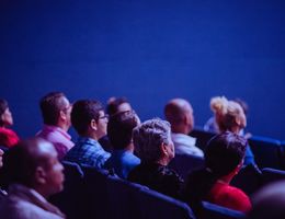 Group of individuals sitting in chairs at an event