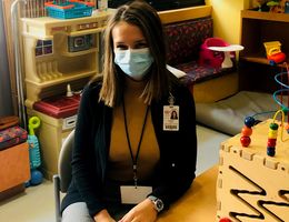 Child Life Specialist MS student Krista Schafer sits in a hospital playroom