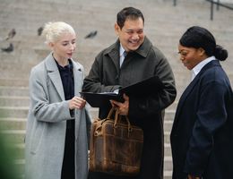 three diverse professionals talking together